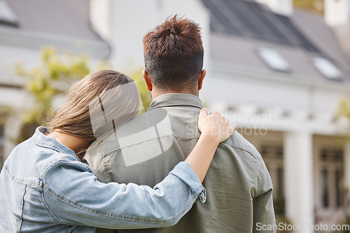 Image of Couple hug outside new home from back, property or future investment opportunity for young people. Mortgage, real estate and marriage, man and woman in backyard of house with love, embrace and moving