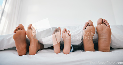 Image of Sleeping, feet and family in a bed with love, relax and resting in comfort in their home together. Barefoot, care and child with mom, father and security in bedroom for sleep, bonding and weekend nap