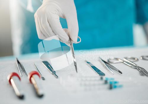 Image of Surgery equipment, table and hands with scissors for a medical procedure in theater. Closeup, hospital and a doctor or surgeon with gear for healthcare, operation or an emergency service in nursing