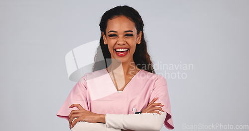 Image of Medical nurse, laughing and a woman in studio with a smile, pride and arms crossed. A happy and friendly female healthcare worker or caretaker on grey background for wellness, medicine and portrait