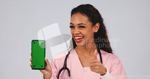 Image of Doctor, thumbs up and phone green screen for medical services, registration and like, yes or ok in studio. Face of healthcare nurse or woman with mobile app and tracking marker on a white background