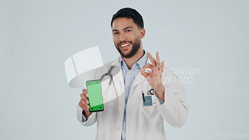 Image of Doctor, phone green screen and yes hand, success or healthcare support, excellence or ok emoji in studio. Face of medical man for mobile telehealth or services, tracking marker and white background