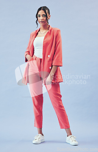 Image of Fashion, portrait and young businesswoman in studio with makeup, confidence and body in suit. Beauty, style and influencer girl in designer clothes, trendy promo and model standing on blue background