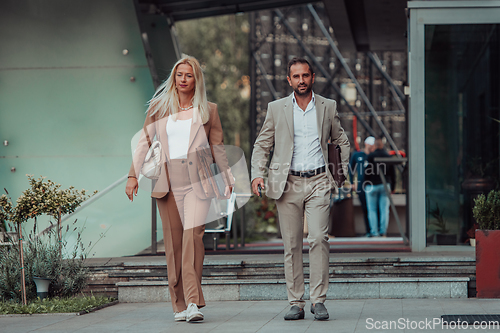 Image of Modern business couple after a long day's work, walking together towards the comfort of their home, embodying the perfect blend of professional success and personal contentment.