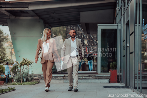 Image of Modern business couple after a long day's work, walking together towards the comfort of their home, embodying the perfect blend of professional success and personal contentment.