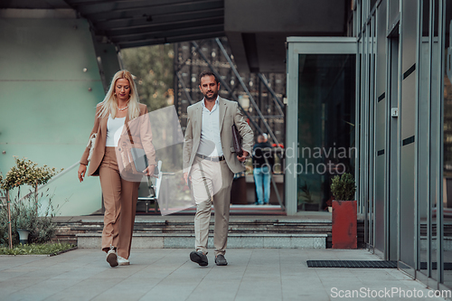 Image of Modern business couple after a long day's work, walking together towards the comfort of their home, embodying the perfect blend of professional success and personal contentment.