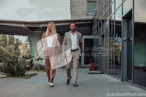 Image of Modern business couple after a long day's work, walking together towards the comfort of their home, embodying the perfect blend of professional success and personal contentment.