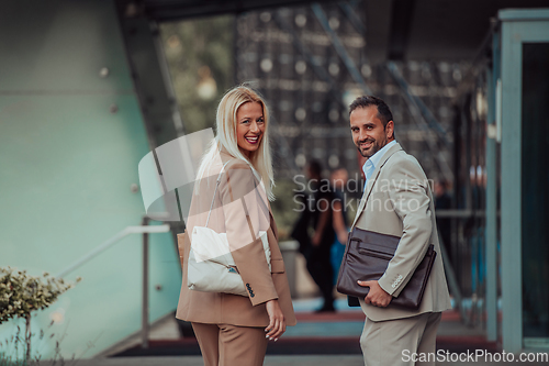 Image of Modern business couple after a long day's work, walking together towards the comfort of their home, embodying the perfect blend of professional success and personal contentment.