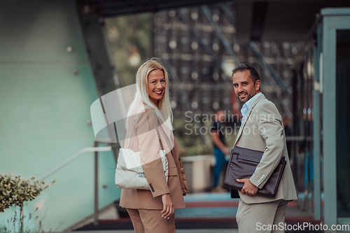 Image of Modern business couple after a long day's work, walking together towards the comfort of their home, embodying the perfect blend of professional success and personal contentment.