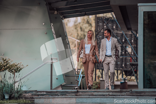 Image of Modern business couple after a long day's work, walking together towards the comfort of their home, embodying the perfect blend of professional success and personal contentment.