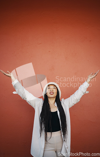 Image of Woman, fashion and arms up for wall and mockup space with urban style and trendy clothing. Freedom, hipster female person and modern confidence with red background and edgy gen z clothes of a girl