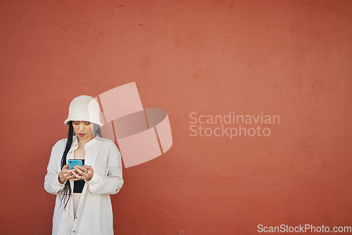 Image of Mockup, wall and woman with phone in a city for travel, search or location map on orange background. Smartphone, app and lady fashion influencer outdoor on social media, blog podcast content creation