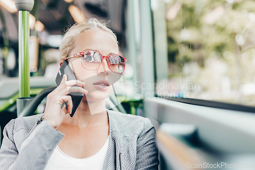 Image of Blonde business woman traveling by bus.