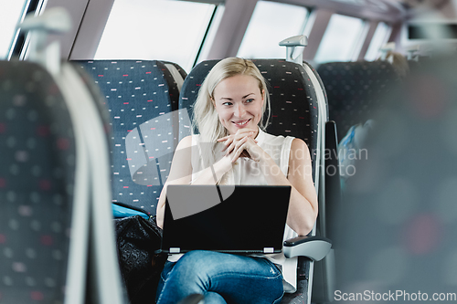 Image of Woman smiling while travelling by train.