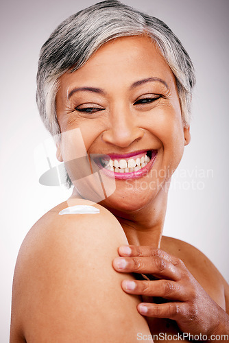 Image of Body cream, shoulder and beauty of a mature woman with glow and smile on a white background. Dermatology, moisturizer and cosmetics of aesthetic model for skin shine, wellness or self care in studio