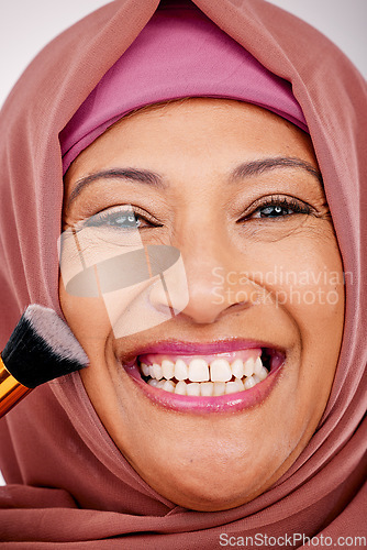 Image of Makeup brush, smile and portrait of muslim woman in studio for cosmetic, natural and face routine. Happy, self care and mature islamic female model with cosmetology tool for facial glamour treatment.