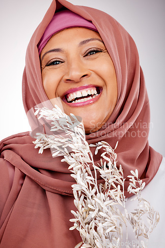 Image of Happy muslim woman, portrait and face with hijab, plant or fashion against a studio background. Islam, female person and scarf with smile in happiness for religion, stylish clothing or natural beauty