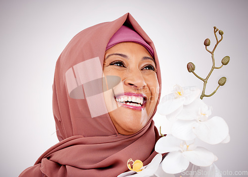 Image of Smile, thinking and Muslim woman with flowers in studio isolated on white background. Happy Islamic model with floral plant for skincare, orchid for healthy skin or organic makeup for beauty cosmetic