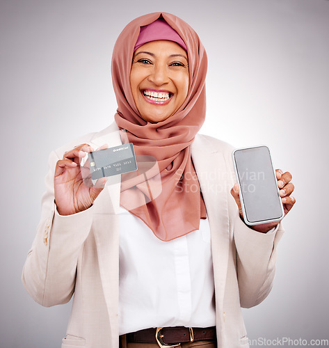 Image of Muslim woman, ecommerce and credit card with a phone on a studio background for online shopping. Happy, portrait and an Islamic person with a mobile app for banking, finance management and payment