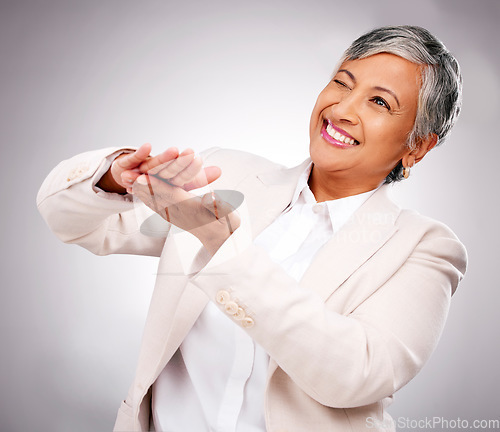 Image of Money, hands and wink by senior business woman in studio happy with investment, growth or payment on grey background. Profit, success and elderly female CEO smile for 401k, emoji or loan promotion