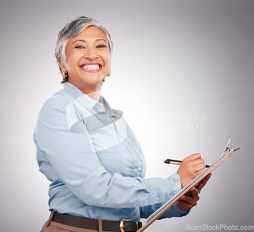 Image of Portrait, clipboard and mature happy woman writing assessment notes, inspection info or compliance survey. Studio, paperwork and business manager working on report, agenda or list on gray background
