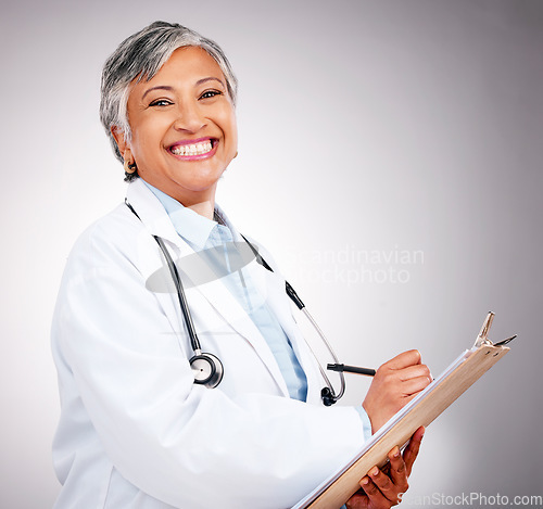 Image of Happy, notes and portrait of woman or doctor writing feedback, healthcare advice or results. Smile, hospital and mature medical employee or nurse with insurance documents on a studio background