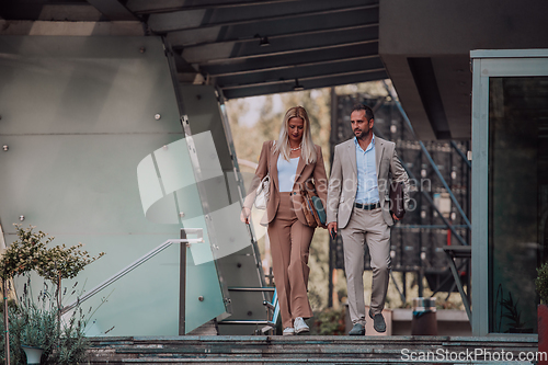 Image of Modern business couple after a long day's work, walking together towards the comfort of their home, embodying the perfect blend of professional success and personal contentment.