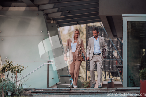 Image of Modern business couple after a long day's work, walking together towards the comfort of their home, embodying the perfect blend of professional success and personal contentment.