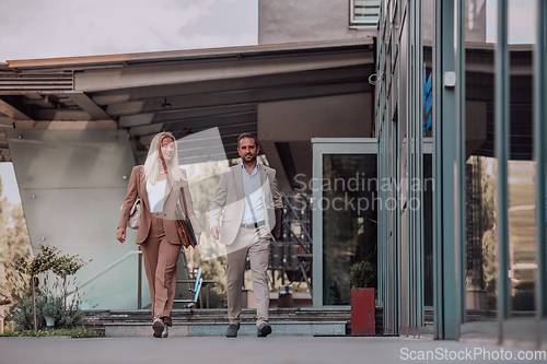 Image of Modern business couple after a long day's work, walking together towards the comfort of their home, embodying the perfect blend of professional success and personal contentment.