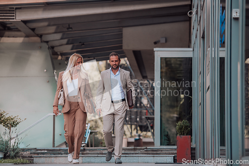 Image of Modern business couple after a long day's work, walking together towards the comfort of their home, embodying the perfect blend of professional success and personal contentment.