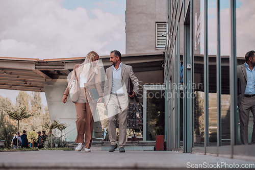 Image of Modern business couple after a long day's work, walking together towards the comfort of their home, embodying the perfect blend of professional success and personal contentment.