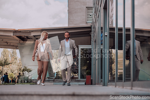 Image of Modern business couple after a long day's work, walking together towards the comfort of their home, embodying the perfect blend of professional success and personal contentment.