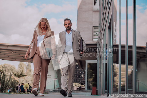 Image of Modern business couple after a long day's work, walking together towards the comfort of their home, embodying the perfect blend of professional success and personal contentment.