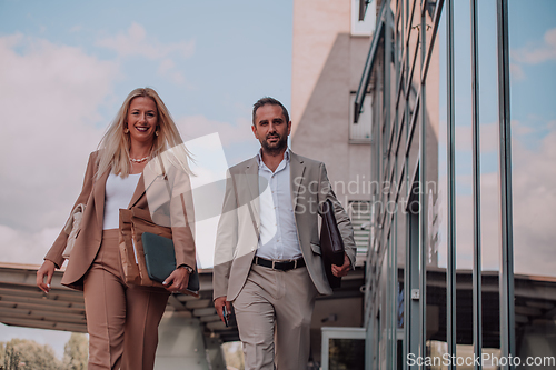 Image of Modern business couple after a long day's work, walking together towards the comfort of their home, embodying the perfect blend of professional success and personal contentment.