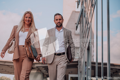 Image of Modern business couple after a long day's work, walking together towards the comfort of their home, embodying the perfect blend of professional success and personal contentment.