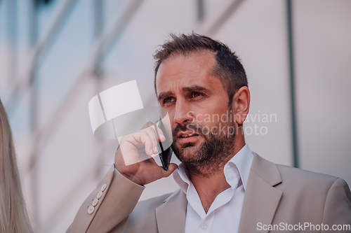 Image of A businessman using his smartphone outdoors, showcasing the seamless integration of technology and mobility in modern professional life.