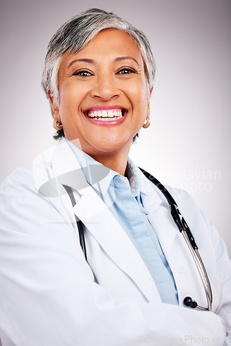 Image of Woman, portrait and doctor smile in studio with arms crossed for consulting of healthcare services. Happy mature surgeon, expert therapist and medical professional with experience on grey background