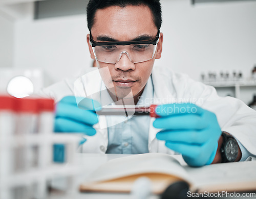 Image of Science, blood test and man in laboratory for medical analysis, health inspection or vaccine development. Asian scientist studying tube for dna results, chemistry investigation or planning assessment