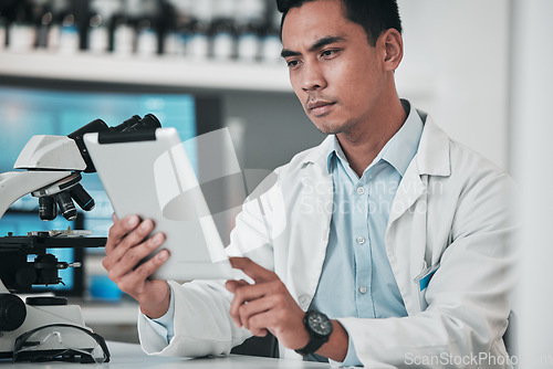 Image of Scientist, man and tablet for laboratory research, data analysis and reading microscope results or test report. Doctor or medical expert on digital technology, science software and healthcare review