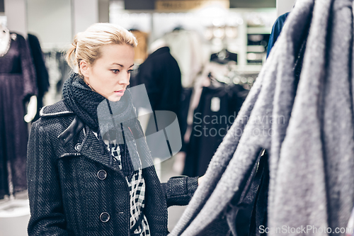 Image of Beautiful woman shopping in clothing store.