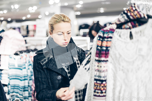 Image of Beautiful woman shopping in clothing store.