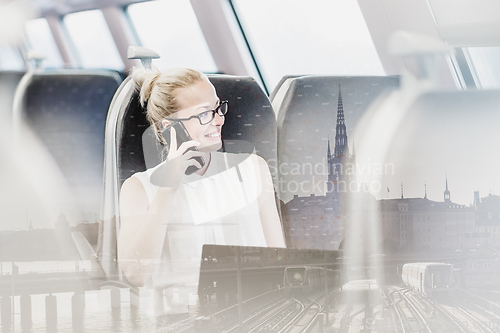 Image of Business woman working while travelling by train.