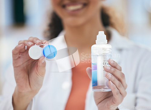 Image of Optometry, contact lens and solution in hands, container and healthcare with eye care and wellness closeup. Person with bottle, vision and optometrist at clinic, case for lenses with advice and help