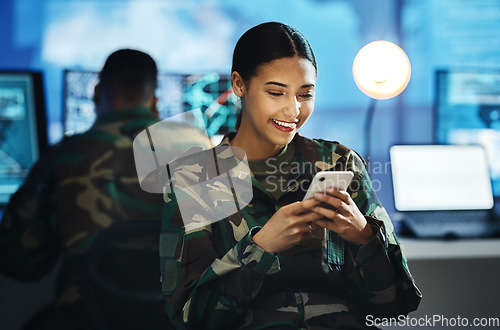 Image of Phone, military and woman soldier in the control room in uniform for war or battle networking. Happy, smile and young female army warrior typing a message on internet with cellphone for surveillance.