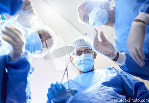 Image of Hospital, tools and surgeon team in theatre for emergency, healthcare or medical procedure. POV, below and doctors for collaboration, portrait or surgery and operation with support and scrubs in ICU