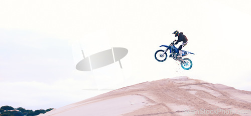Image of Sand, jump or athlete driving motorbike for action, adventure or fitness with performance or adrenaline. Speed, air or driver on motorcycle on dunes hill for training, exercise or race challenge