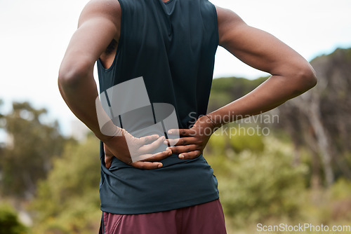 Image of Fitness, nature and a person with back pain after hiking with a sports injury or accident. Tired, healthcare and an athlete or runner with muscle strain, inflammation or emergency after training