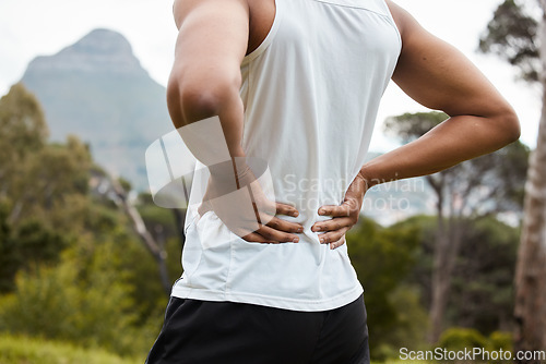 Image of Fitness, nature and a person with back pain after running with a sports injury or accident. Tired, healthcare and an athlete or runner with muscle strain, inflammation or emergency after training