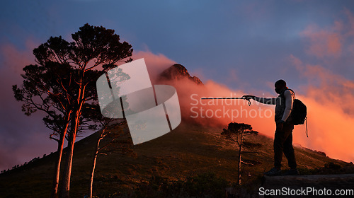 Image of Goal, pointing and a man hiking in the mountains at night for travel, freedom or to explore remote nature. Sky, motivation and dark with a backpacker trekking in the forest for adventure on space