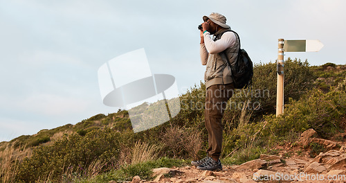 Image of Hiker, binocular or black man on mountain in nature on trekking journey or adventure for fitness. Hiking, holiday vacation or African person walking to search in park for exercise or view on hill